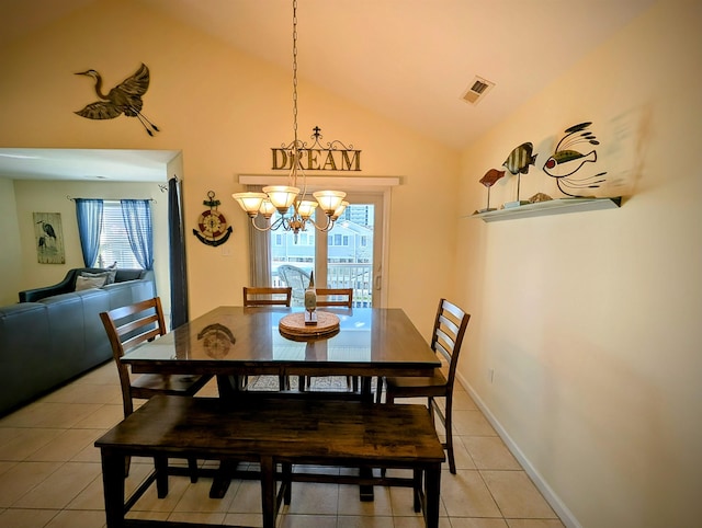 dining area with lofted ceiling, light tile patterned floors, and a chandelier