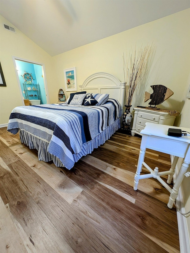 bedroom with hardwood / wood-style floors and lofted ceiling