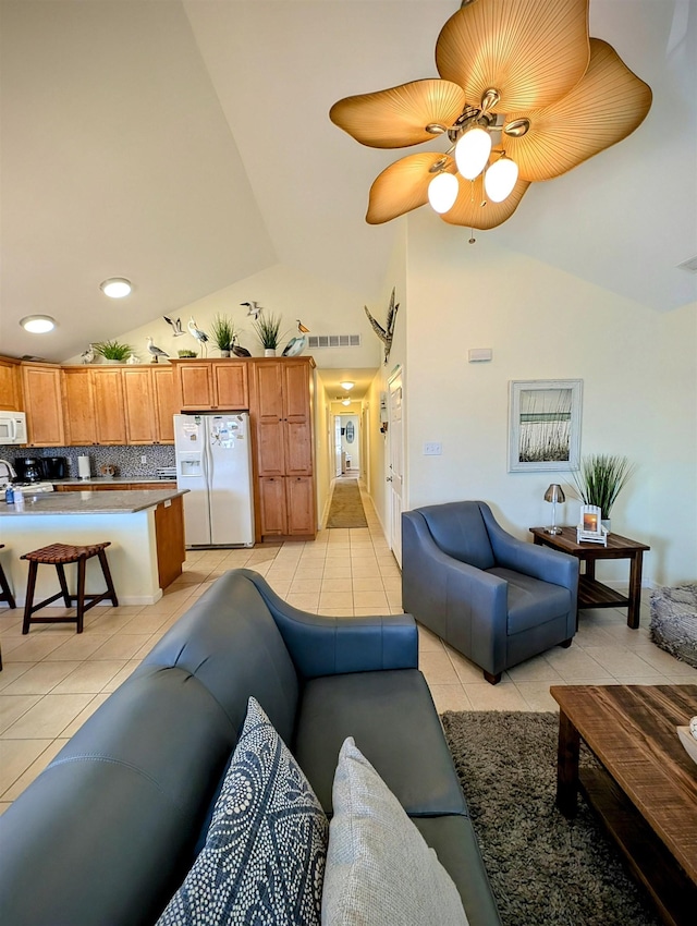 tiled living room featuring ceiling fan and lofted ceiling