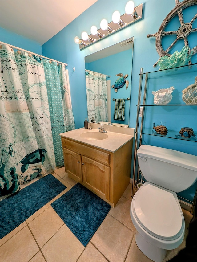 bathroom featuring tile patterned flooring, vanity, toilet, and curtained shower