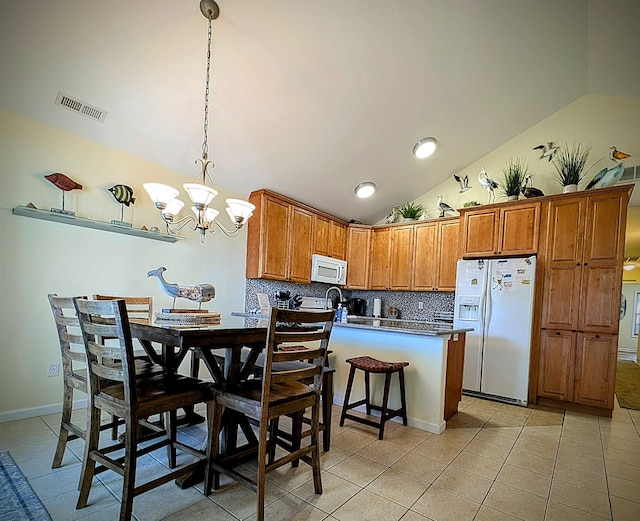 kitchen featuring hanging light fixtures, a notable chandelier, backsplash, vaulted ceiling, and white appliances