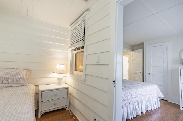 bedroom featuring dark hardwood / wood-style floors and wood walls