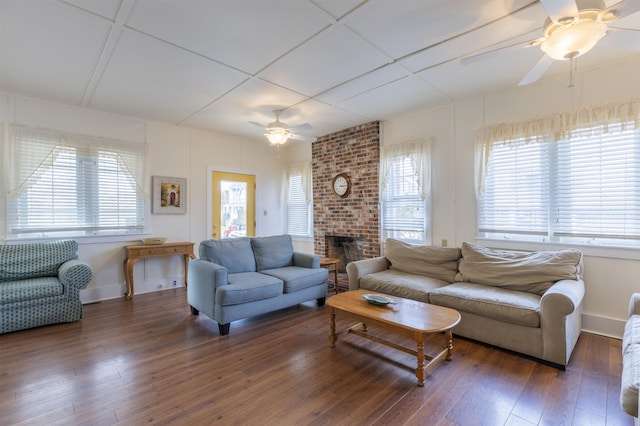 living room featuring a fireplace, dark hardwood / wood-style floors, and ceiling fan