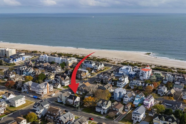 drone / aerial view featuring a water view and a beach view