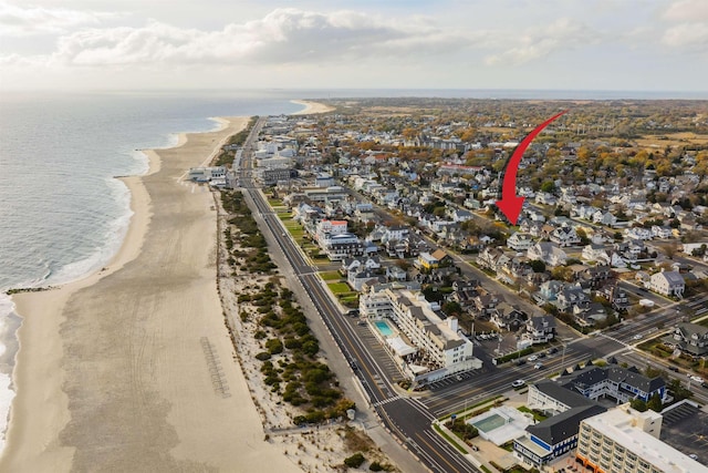 drone / aerial view featuring a beach view and a water view