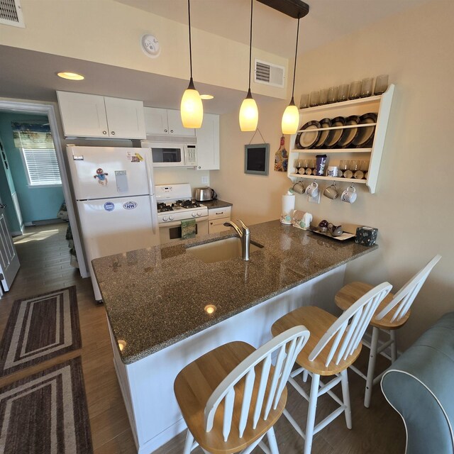 1800 Ocean Ave Unit 515, North Wildwood, NJ 08260 - kitchen with white appliances, a peninsula, a sink, white cabinets, and dark stone counters
