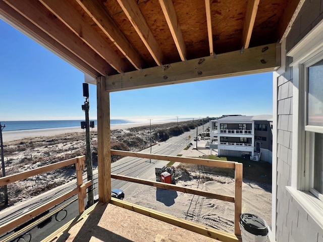 balcony featuring a view of the beach and a water view