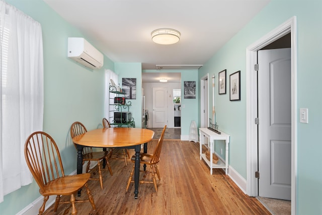 dining room with light hardwood / wood-style floors and a wall mounted AC