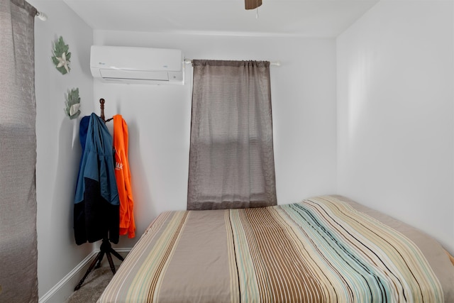 bedroom with ceiling fan and an AC wall unit