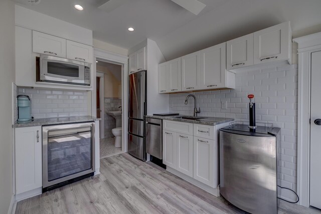 2901 Pacific Ave, Wildwood, NJ 08260 - kitchen featuring light wood-type flooring, a sink, beverage cooler, light stone countertops, and appliances with stainless steel finishes