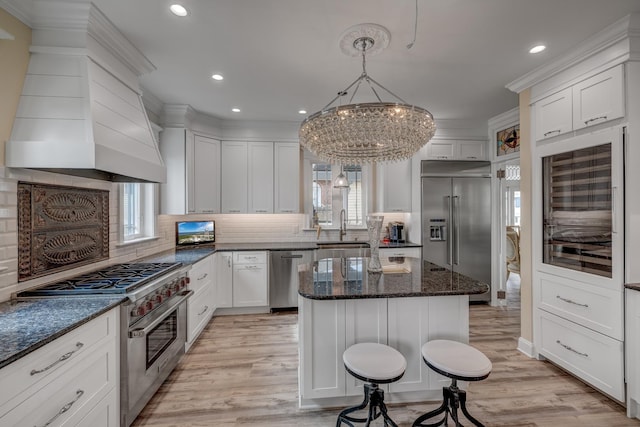 2901 Pacific Ave, Wildwood, NJ 08260 - kitchen featuring high end appliances, a notable chandelier, a sink, white cabinetry, and custom exhaust hood