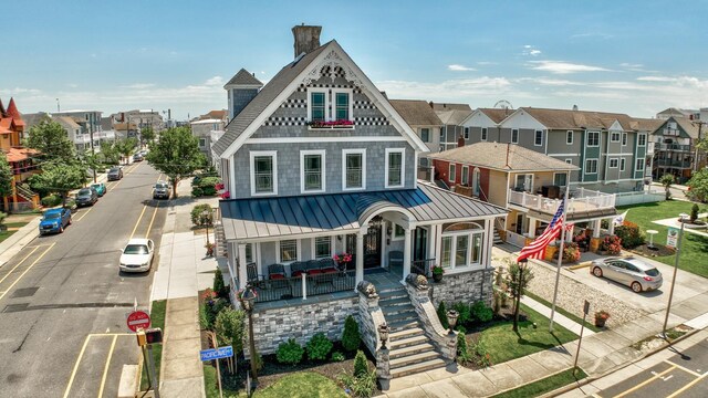 2901 Pacific Ave, Wildwood, NJ 08260 - view of front of house featuring stone siding, a standing seam roof, a residential view, metal roof, and a porch
