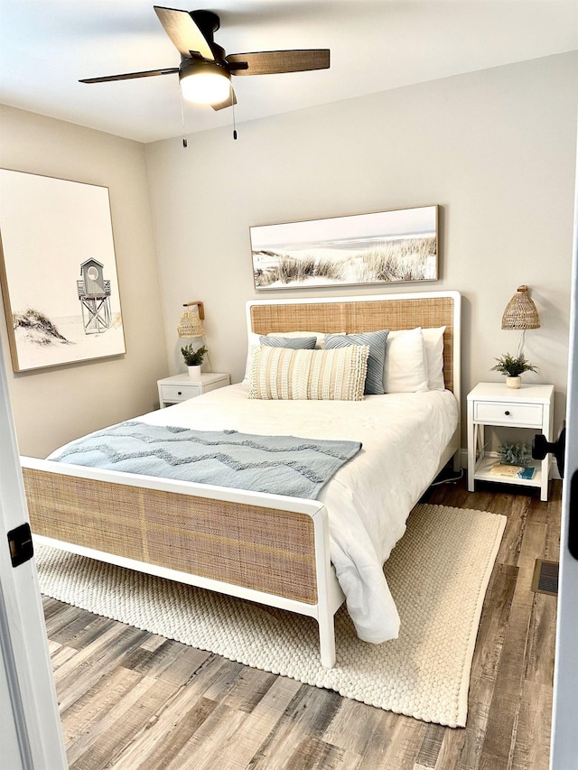 bedroom featuring ceiling fan, visible vents, and wood finished floors