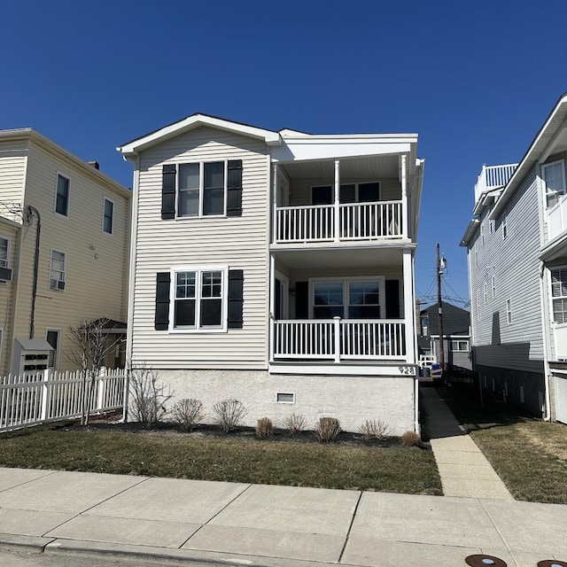 view of front of house with a balcony and fence