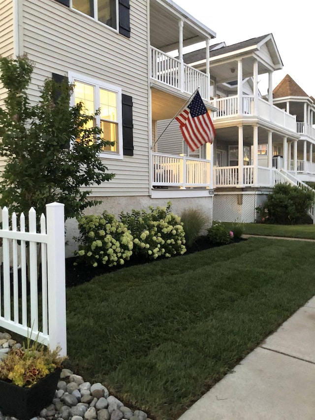 view of side of home featuring a balcony and a yard