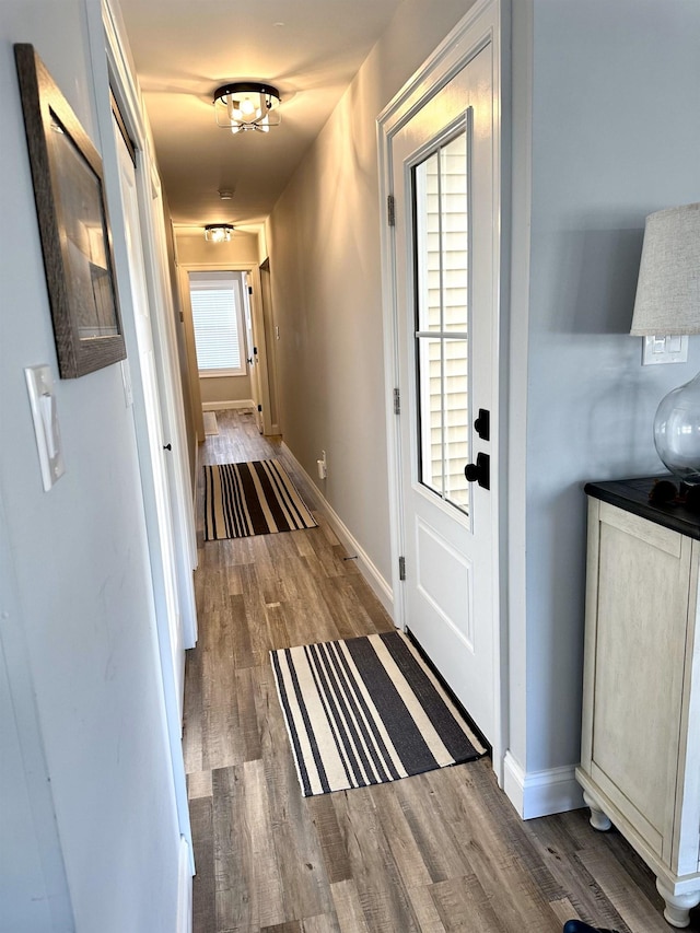 doorway to outside with baseboards and wood finished floors