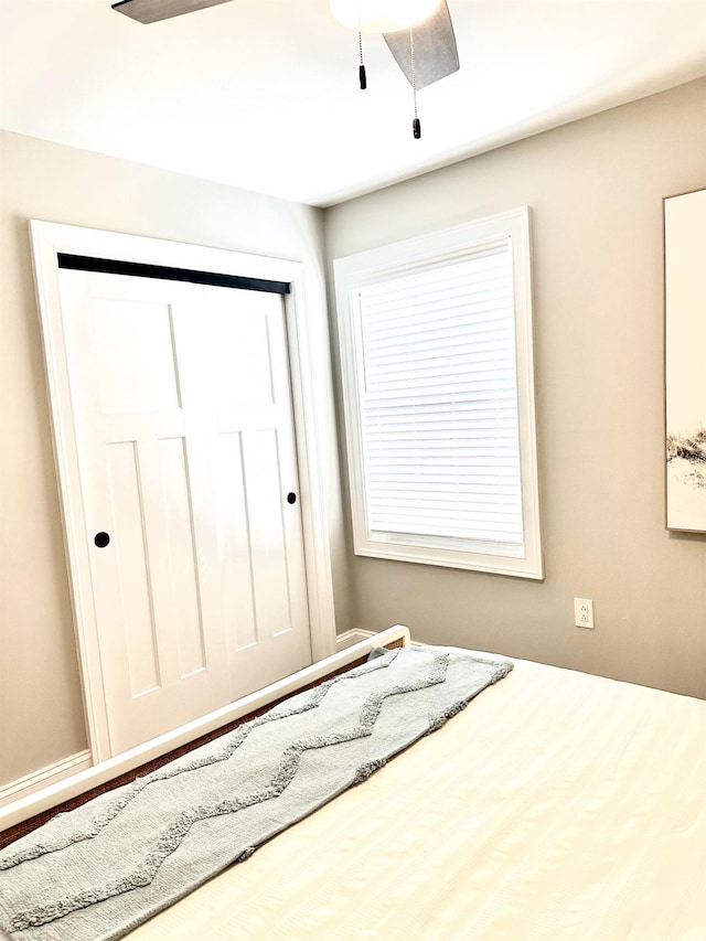 unfurnished bedroom featuring a closet and a ceiling fan