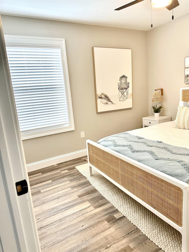 bedroom with baseboards, wood finished floors, and a ceiling fan