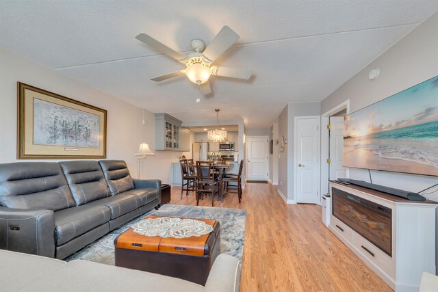 9907 Seapointe Blvd Unit 215, Lower Township, NJ 08260 - living area featuring ceiling fan, light wood finished floors, and a chandelier