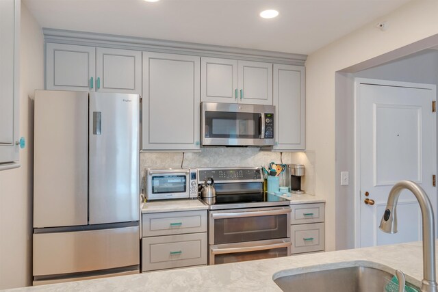 9907 Seapointe Blvd Unit 215, Lower Township, NJ 08260 - kitchen featuring appliances with stainless steel finishes, gray cabinetry, backsplash, recessed lighting, and light stone counters