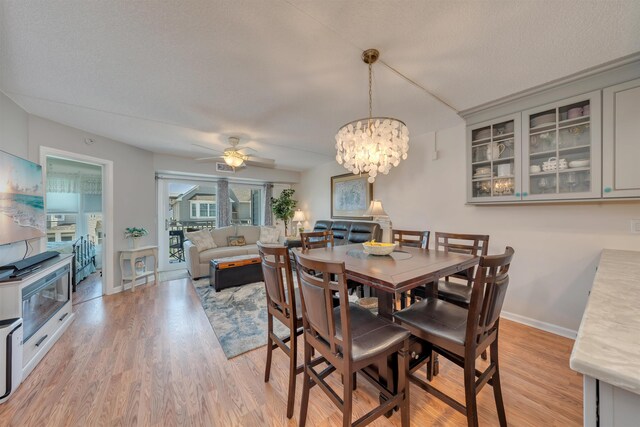 9907 Seapointe Blvd Unit 215, Lower Township, NJ 08260 - dining space featuring a ceiling fan, light wood-style flooring, a chandelier, and a textured ceiling