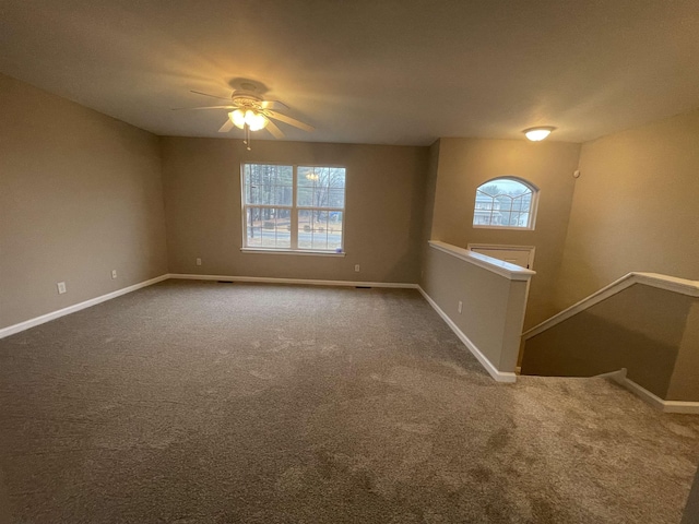 carpeted spare room with ceiling fan