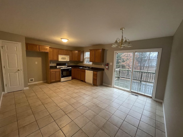 kitchen featuring white appliances, an inviting chandelier, sink, light tile patterned floors, and decorative light fixtures