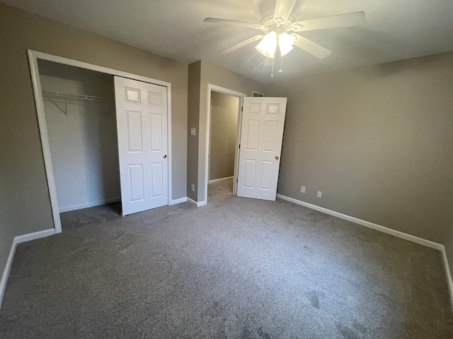 unfurnished bedroom featuring dark colored carpet, a closet, and ceiling fan