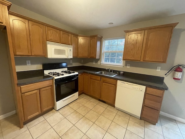 kitchen with light tile patterned flooring, white appliances, and sink