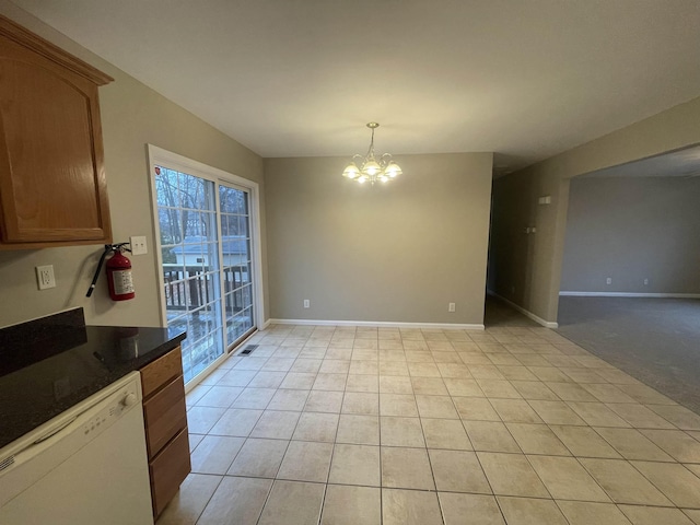 unfurnished dining area featuring light tile patterned floors and a notable chandelier