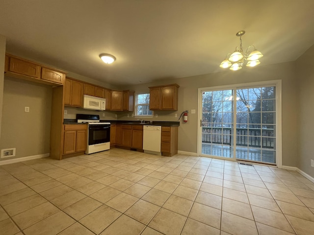 kitchen featuring white appliances, decorative light fixtures, an inviting chandelier, and light tile patterned flooring