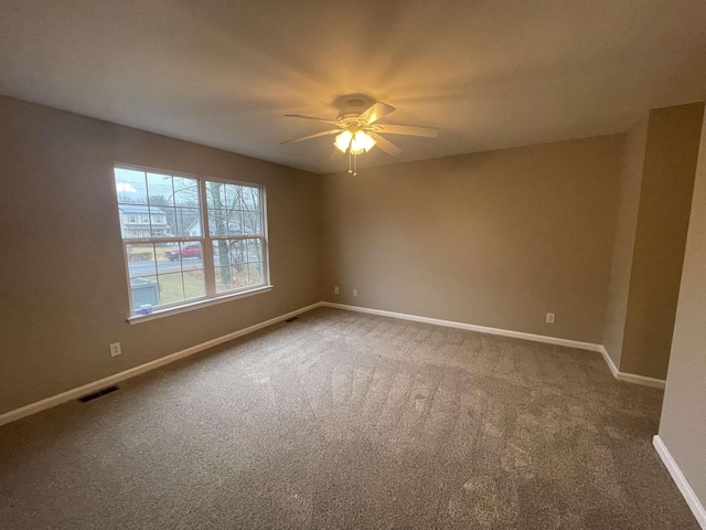 carpeted spare room featuring ceiling fan