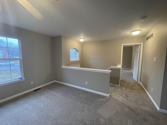 unfurnished room featuring dark carpet