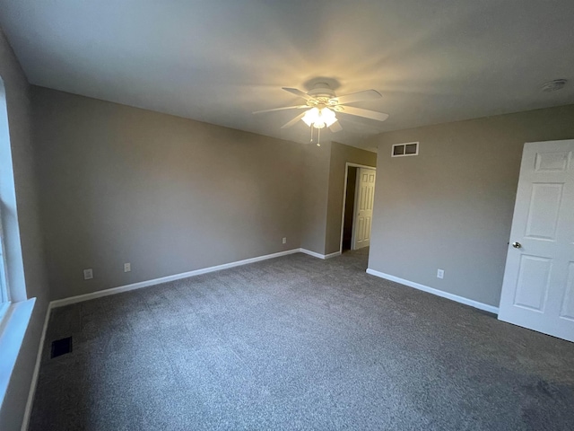 unfurnished room with dark colored carpet and ceiling fan