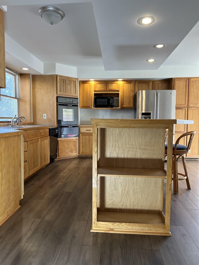 kitchen featuring ceiling fan, a fireplace, and wood walls