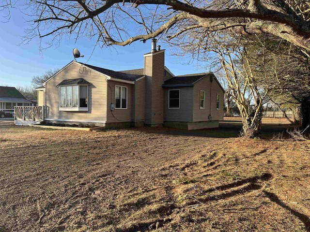 view of home's exterior with a lawn and a deck