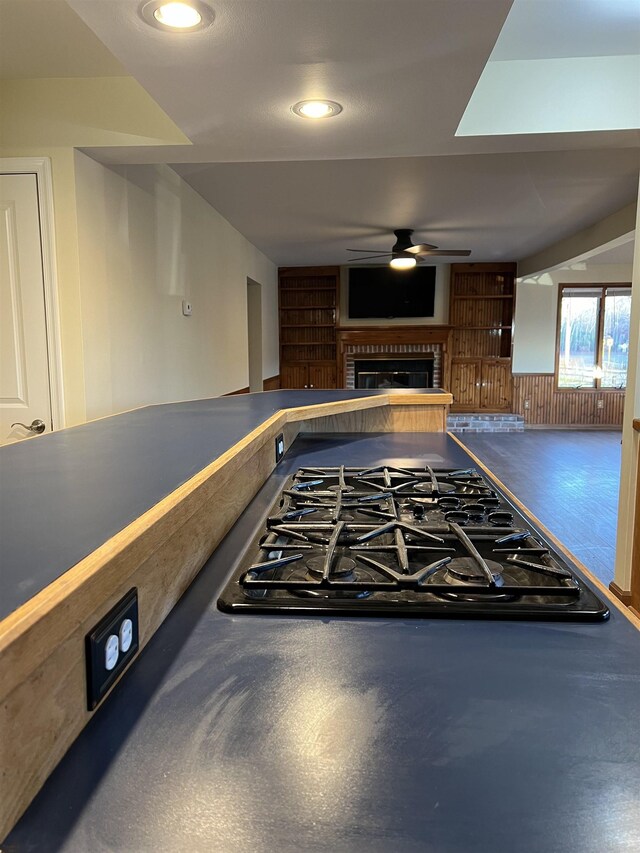 kitchen with dark wood-type flooring, a kitchen breakfast bar, kitchen peninsula, and black appliances