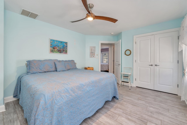 bedroom with visible vents, a closet, baseboards, light wood-style flooring, and ceiling fan