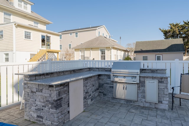 view of patio / terrace with an outdoor kitchen, area for grilling, and fence