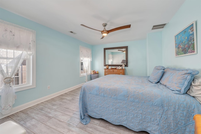bedroom with baseboards, visible vents, light wood-style floors, and ceiling fan