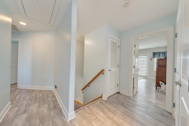 hallway featuring an upstairs landing, attic access, light wood-style flooring, baseboards, and recessed lighting