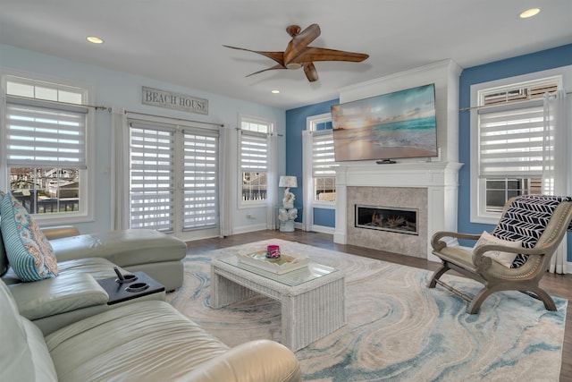 living area with a tiled fireplace, a ceiling fan, wood finished floors, and recessed lighting