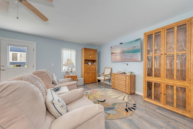 living area with ceiling fan and light wood-style flooring