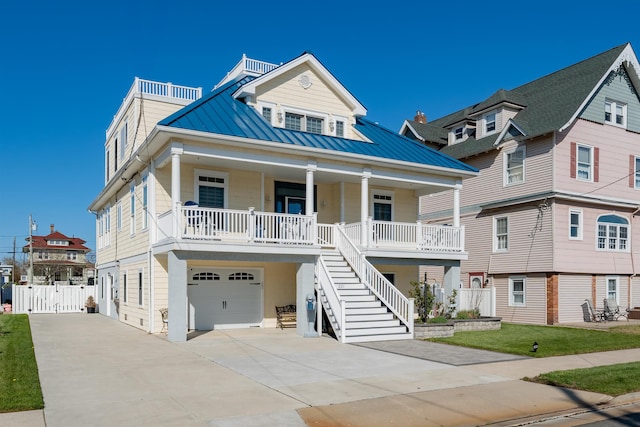 raised beach house with driveway, an attached garage, a porch, metal roof, and stairs