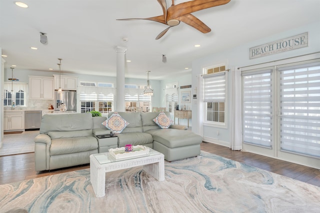 living room featuring light wood-type flooring, a wealth of natural light, and ceiling fan