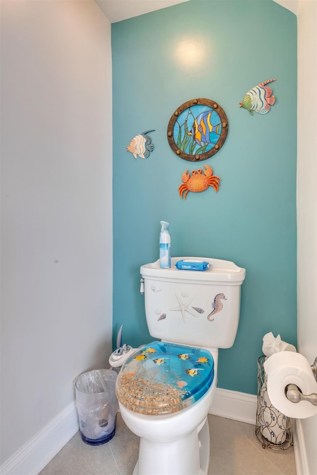 half bath featuring tile patterned floors, baseboards, and toilet