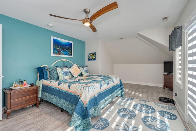 bedroom featuring ceiling fan, lofted ceiling, wood finished floors, and visible vents