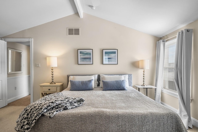 bedroom with lofted ceiling with beams, carpet floors, wainscoting, and visible vents