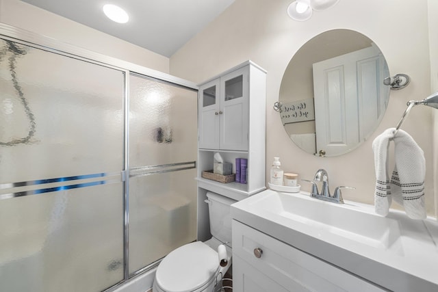 full bath featuring toilet, a shower stall, and vanity