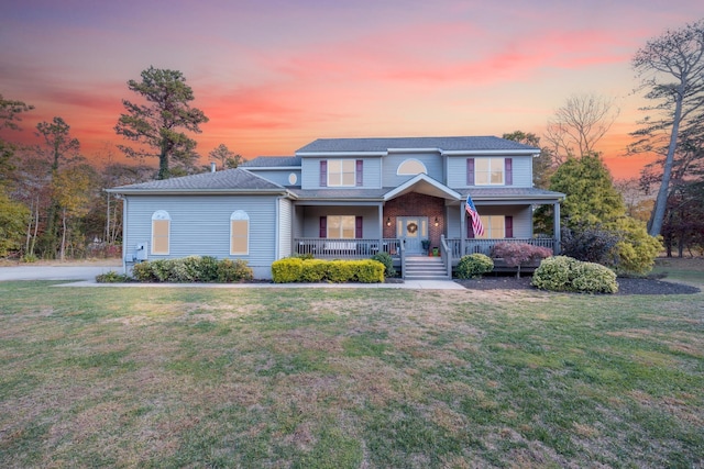 view of front of home with a porch and a lawn